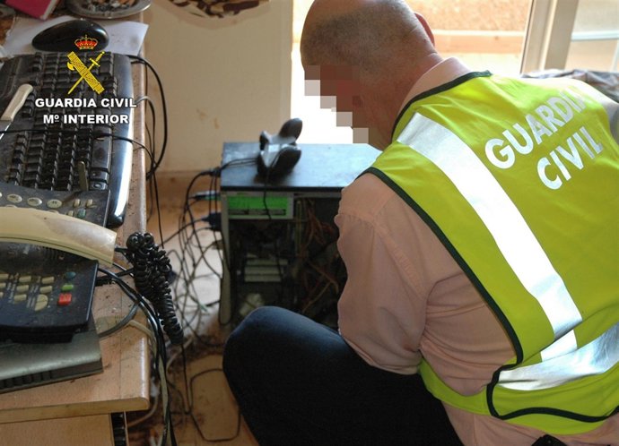 Un guardia civil manipula uno de los ordenadores intervenidos