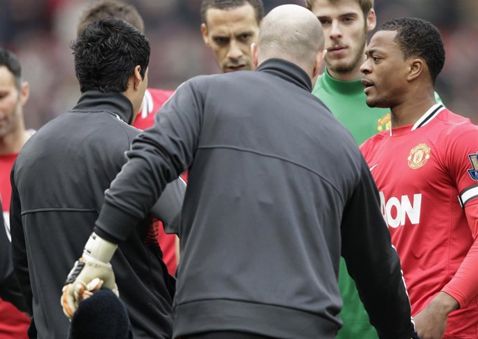Evra y Luis Suárez se saludan en un Liverpool-United