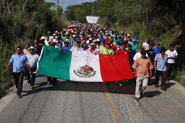 People hold a Mexican flag with the word 