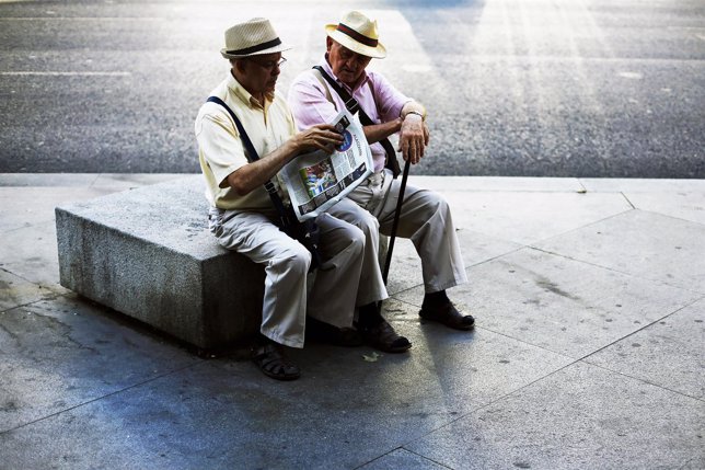 Two elderly men read the paper together in central Madrid September 9, 2014. REU