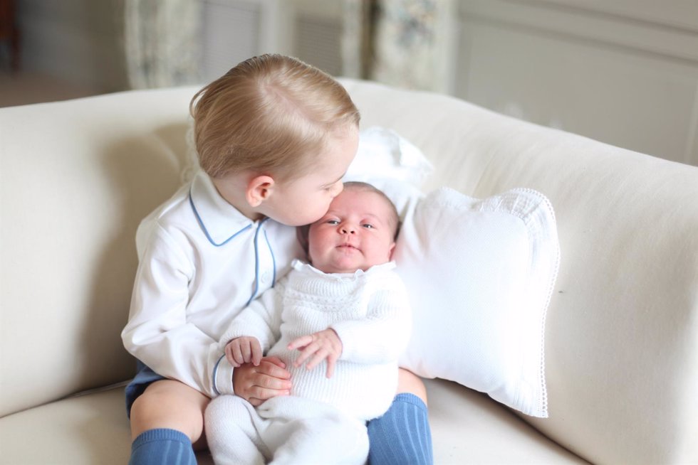 Príncipe George sostiene a la Princesa Charlotte en brazos