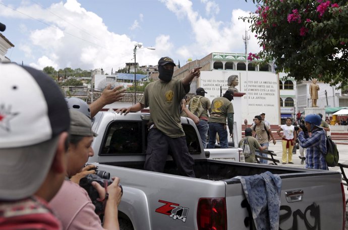 A community policeman on a truck points as he is confronted by Tixtla villagers,