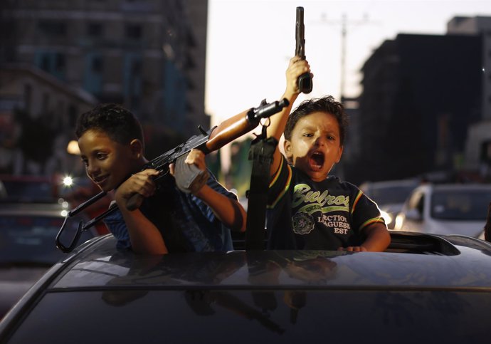 Niños palestinos celebran el alto al fuego con Israel con armas en las manos