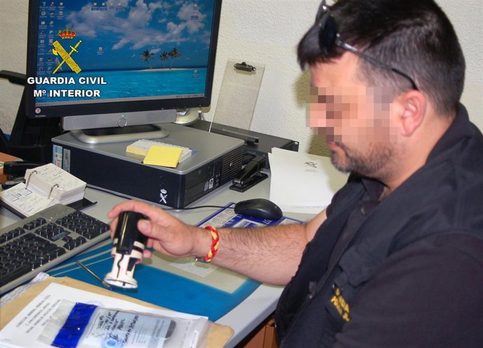 Uno de los investigadores precintando el teléfono móvil incautado 