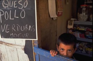 Un niño en un puesto de venta de comida en Cusco (