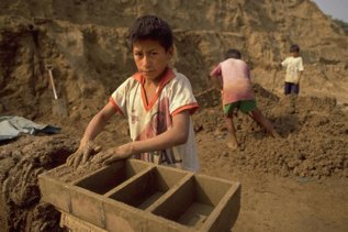 Un niño moldeando un ladrillo en Huachipa, a las a