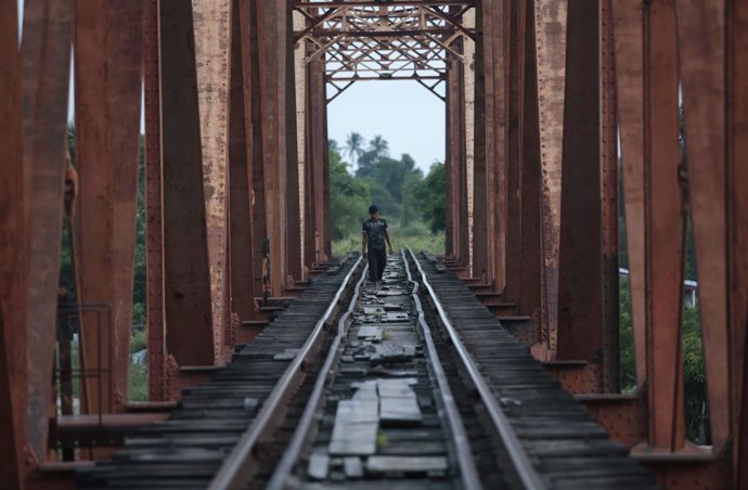 Central American migrant walks on the train tracks in Arriaga