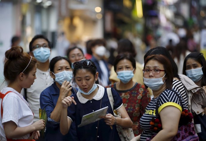A tourist wearing a mask to prevent contracting MERS asks sales assistant for di