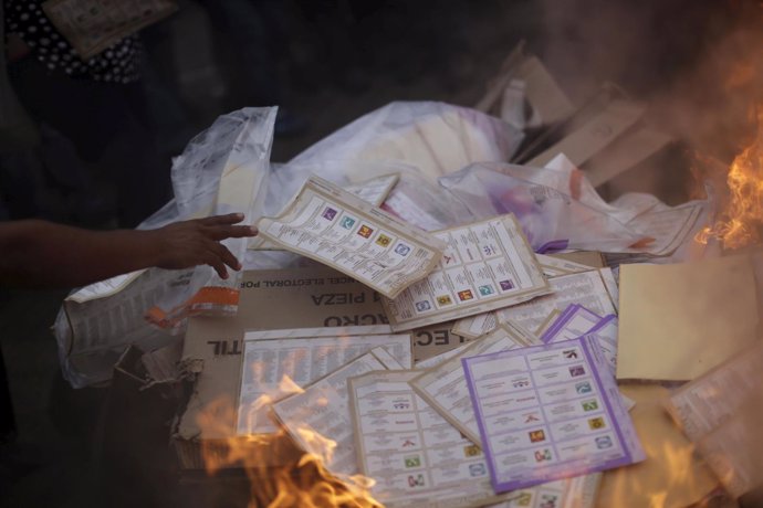 An activist burns ballots and electoral materials in Tixtla, in Guerrero