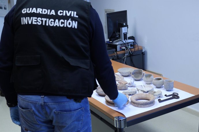Un agente de la Guardia Civil expone las piezas arqueológicas intervenidas.