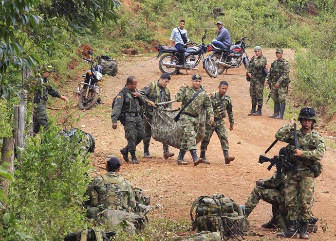 Colombian soliders carry the corpse of a comrade killed after a rebel attack in 