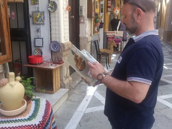 Un ciudadano mira un libro de cocina bookcrossing de gastronomía entorno thyssen