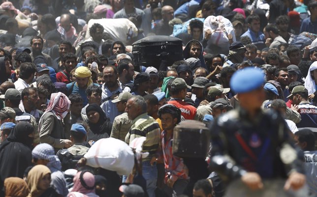 Refugiados sirios huyen de los combates en Tel Abyad hacia Turquía