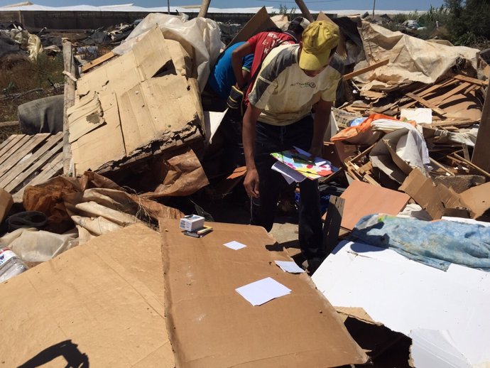 Un inmigrante recoge sus pertenencias de una chabola derruida 12