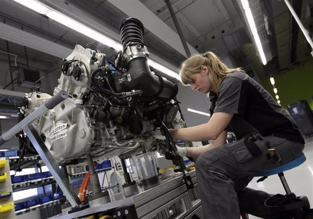 Una trabajadora emsambla el motor de un auto deportivo en una planta manufacture