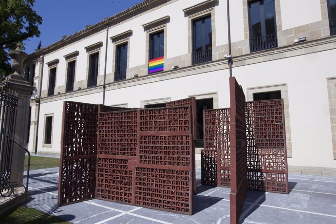 Colocación en fachada del parlamento vasco de la bandera arco iris
