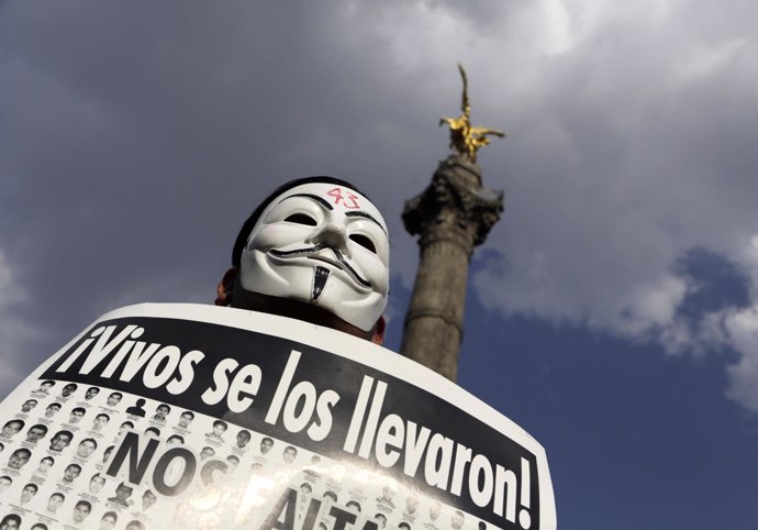 Un manifestante con máscara de Guy Fawkes protesta 42 estudiantes normalistas 