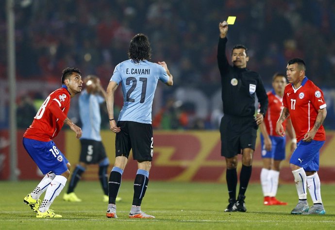 Referee Sandro Ricci shows a second yellow card to Uruguay's Cavani as Chile's J