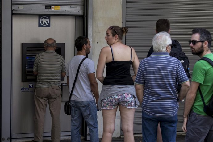 Greigos haciendo cola en un cajero automático de Atenas
