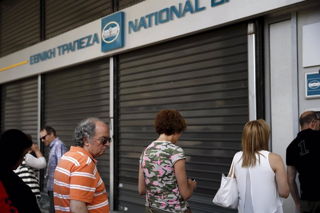 Personas delante de un cajero en un banco de Grecia
