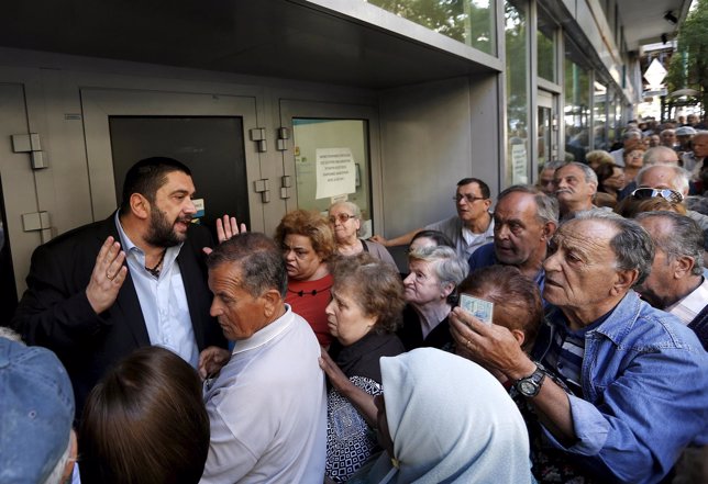 Jubilados griegos delante de un banco