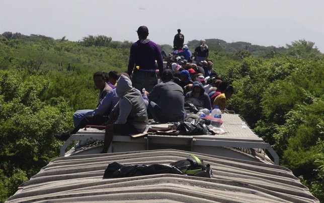 Unaccompanied minors ride atop the wagon of a freight train, known as La Bestia 