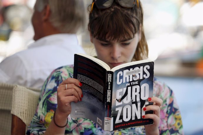 Una mujer lee un libro sobre la crisis griega en Meyisti
