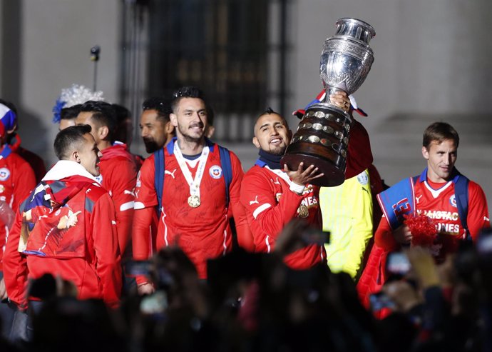 Chile's Arturo Vidal holds the trophy ourside the La Moneda presidential palace 