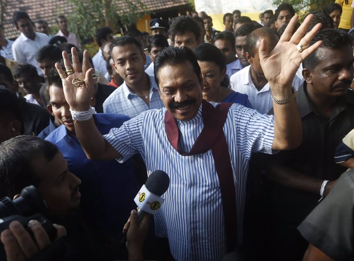 Sri Lanka's President Mahinda Rajapaksa gestures to the media after casting his 