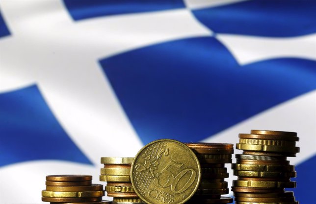 Monedads de euro enfrente de una bandera griega