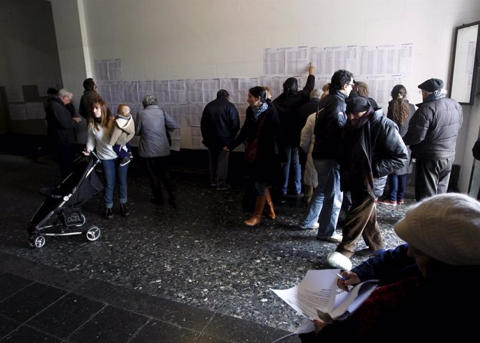Citizens look for their names before voting in an election for Buenos Aires' Cit