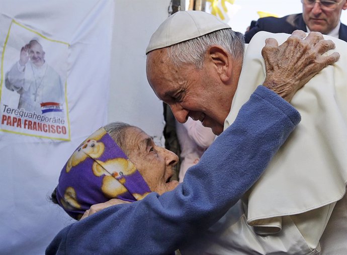 Pope Francis is greeted by a faithful during his visit to the Banado Norte neigh