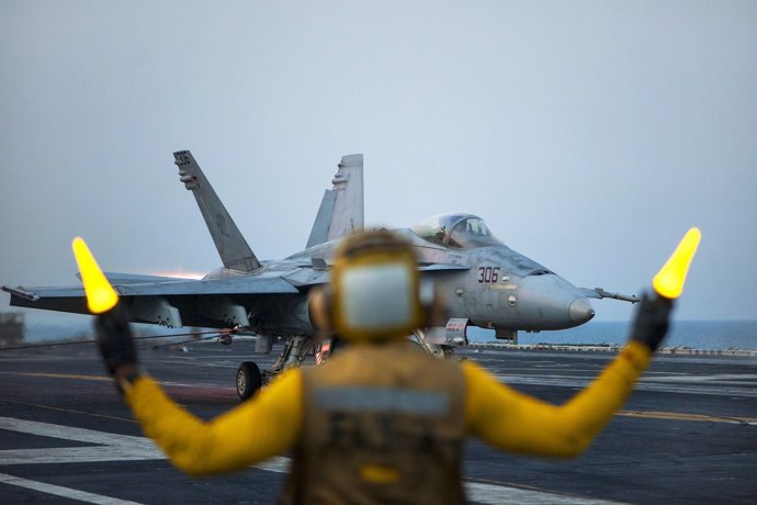 Aviation Boatswain’s Mate (Handling) 2nd Class Ted Casal directs an F/A-18C Horn