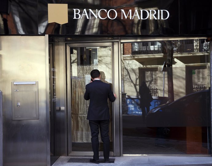 Man enters a Banco Madrid branch with a closed sign on its door in Madrid