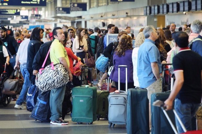 Pasajeros esperando para facturar en un aeropuerto