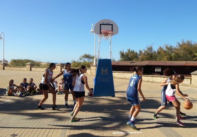 Menores juegan al baloncesto. 