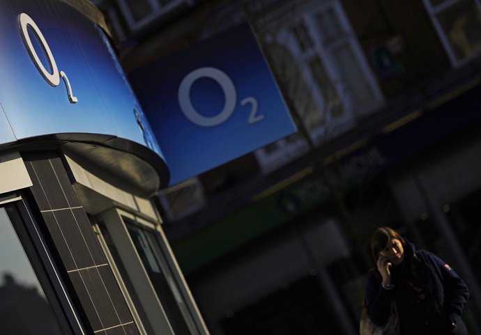 A woman speaks on her mobile telephone outside an O2 shop in Loughborough