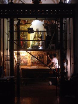 Una de las restauradoras trabajando en el retablo