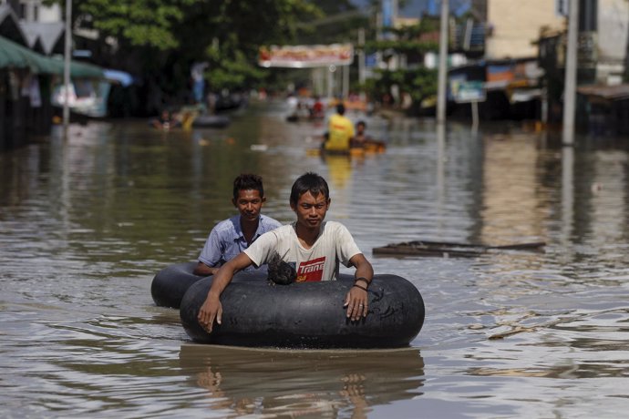 Men wade along a flooded street at Kalay township at Sagaing division
