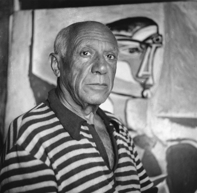 Pablo Picasso con un cuadro de fondo