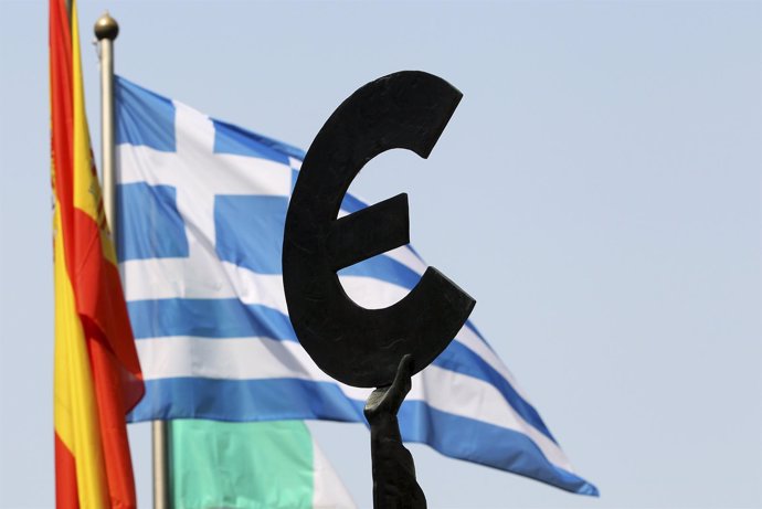A Greek flag flies behind a statue to European unity outside the European Parlia