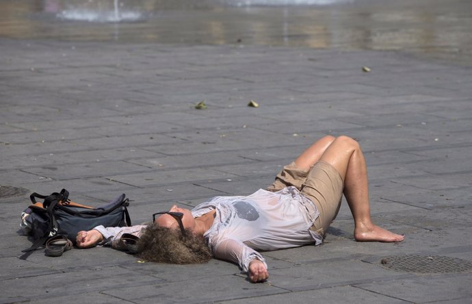 Una mujer tumbada junto a una fuente en Bruselas durante la ola de calor