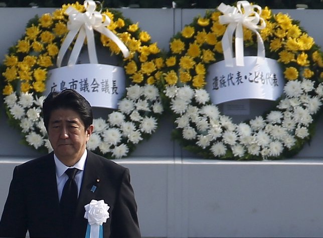 Japan's PM Abe walks as he attends  a ceremony at the Peace Memorial Park in Hir