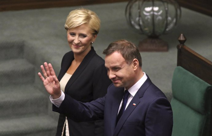 New Polish President Duda waves as he stands next to his wife Kornhauser-Duda af