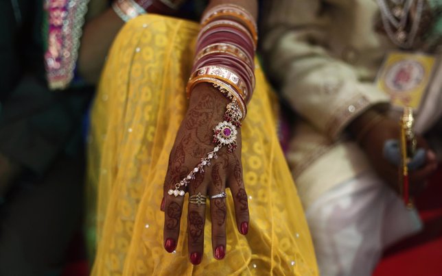 Una mano decorada con henna y joyería durante una boda en India