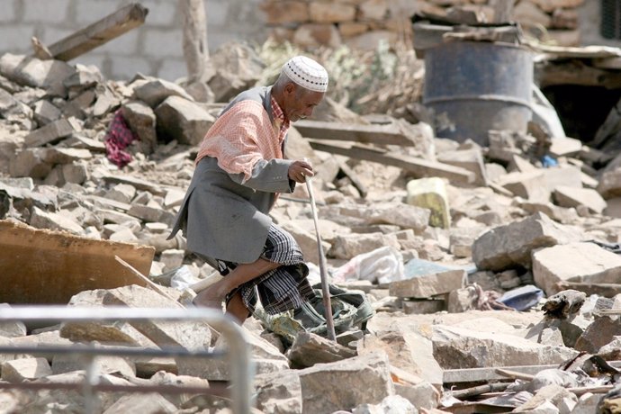 Un anciano camina entre los restos de un edificio en Yemen