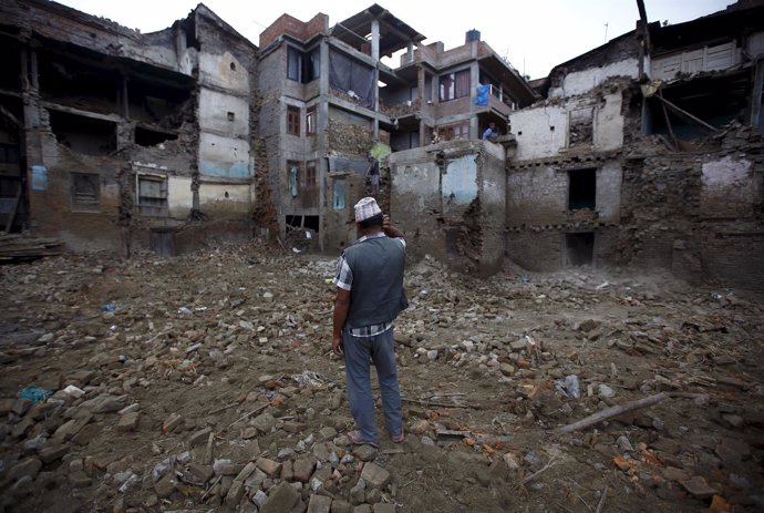 A man stands near collapsed houses that were damaged during the earthquake in Bh
