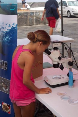 Una niña mirando por un microescopio