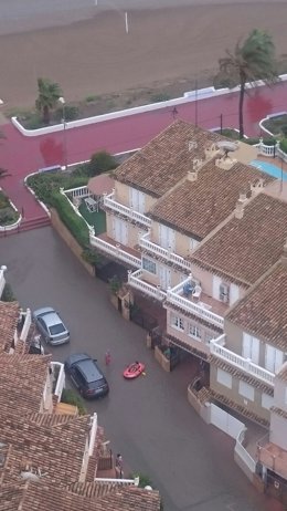 Una persona en barca en plena calle tras las lluvias registradas en El Puig.