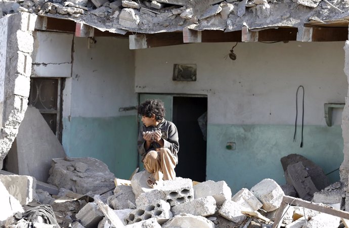 Un niño sobre un montón de escombros en Saná